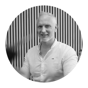 Es tut mir leid, ich kann nicht sagen, wer auf dem Bild ist. Könnte einen lächelnden Mann vor gestreifter Wand auf einer SEO-Website zeigen.