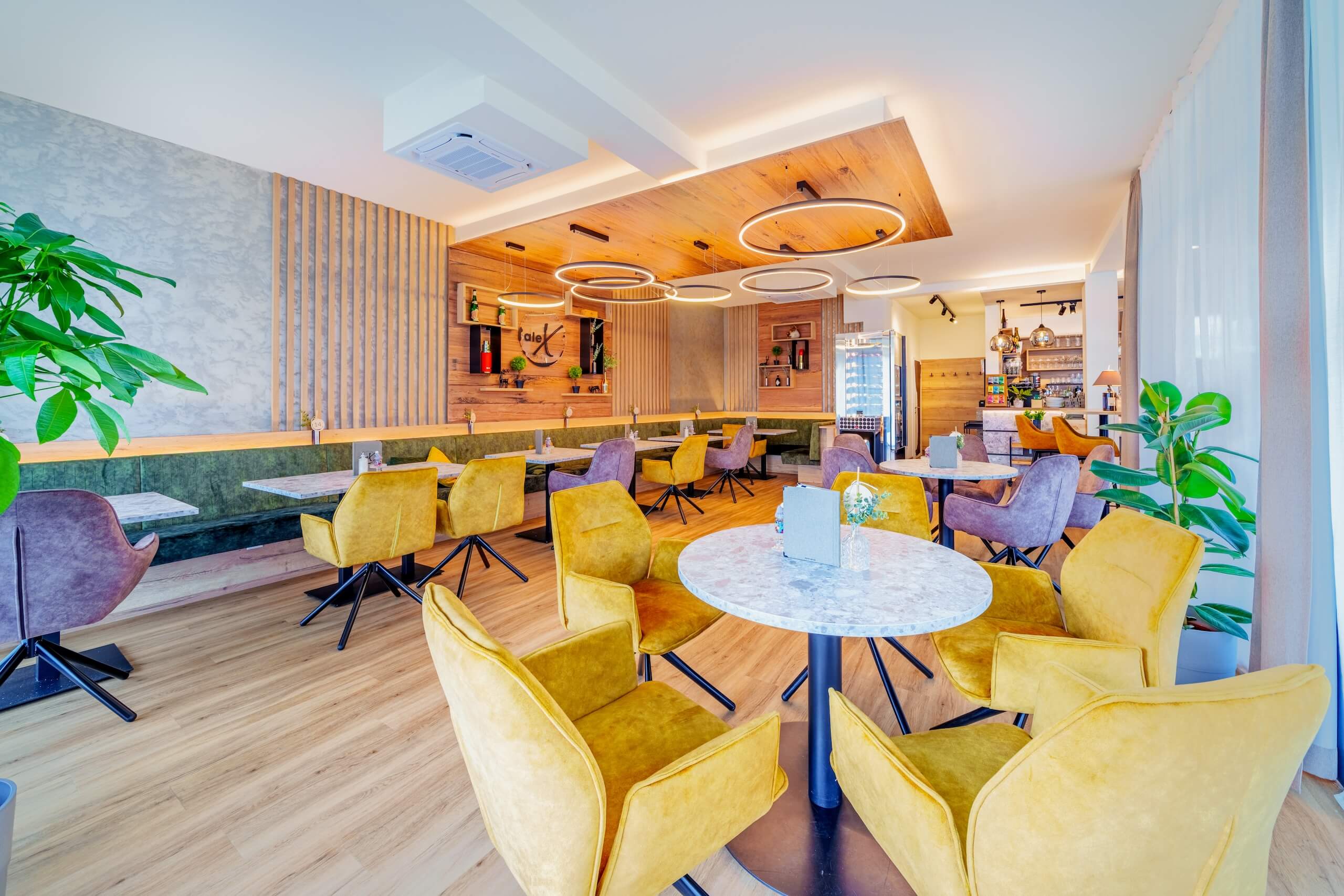 Moderner, gut beleuchteter Speisesaal mit farbenfrohen Stühlen und stilvollem Interieur. Ideal für gemütliches Beisammensein.