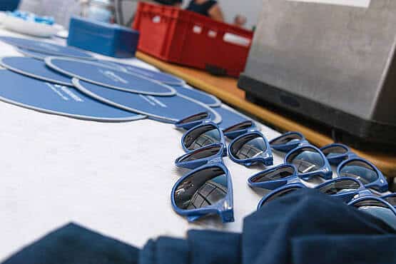 Werbegeschenke mit Sonnenbrillen und Fächern am Tisch, im Büro der WordPress Agentur Webschmiede in Oberwart, Burgenland.