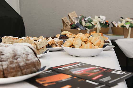 Buffet mit Gebäck und Flyern, präsentiert von Webschmiede, WordPress Agentur in Oberwart für Webdesign und SEO.