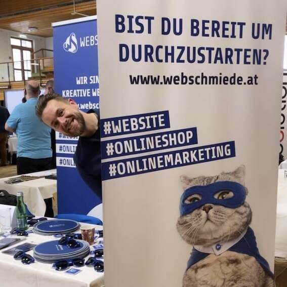 WordPress Agentur-Messeauftritt mit Roll-up, Person lächelt; Slogans zu Websites, Onlineshop, Online-Marketing.