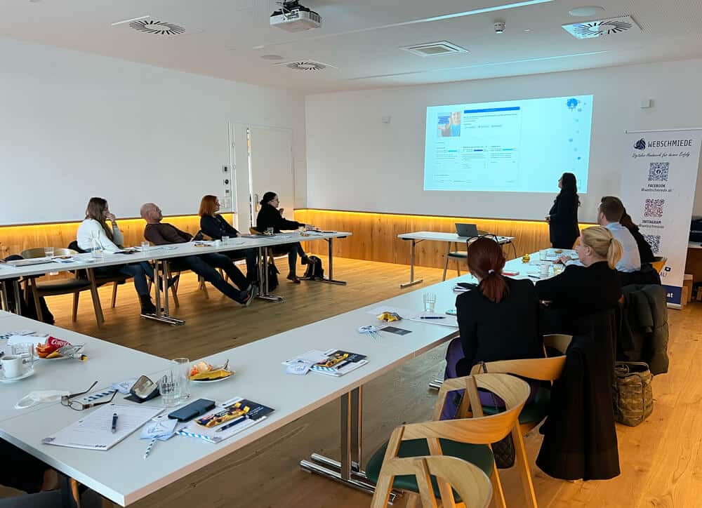Teamworkshop bei Webschmiede, einer WordPress-Agentur in Oberwart, mit Präsentation über Webdesign und SEO an großer Leinwand.
