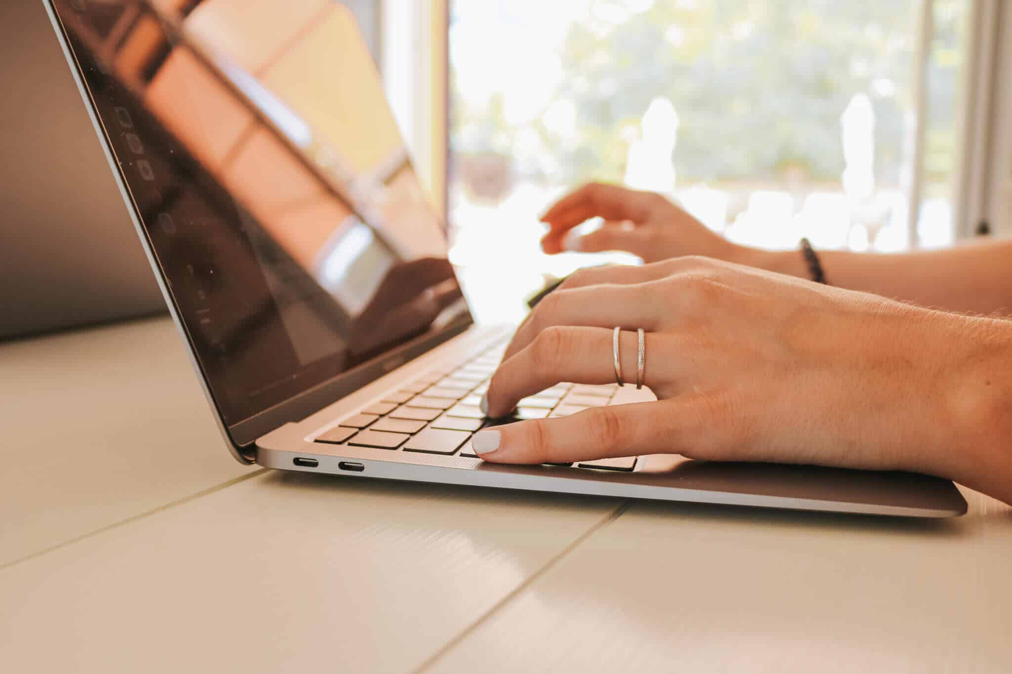 Hände einer Person tippen auf einem Laptop, Webdesign-Arbeit für eine WordPress-Agentur in Oberwart, Burgenland.