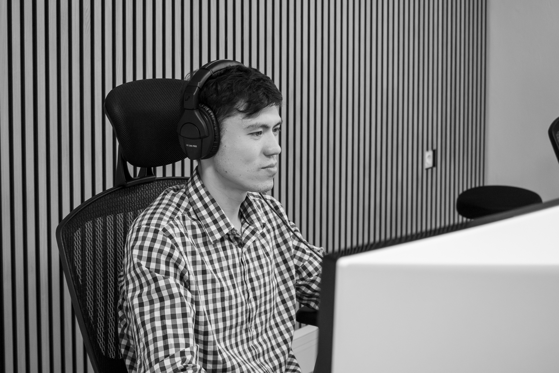 Mitarbeiter der Webschmiede arbeitet konzentriert am Computer, trägt Kopfhörer im modernen Büro für WordPress-Webdesign und SEO.