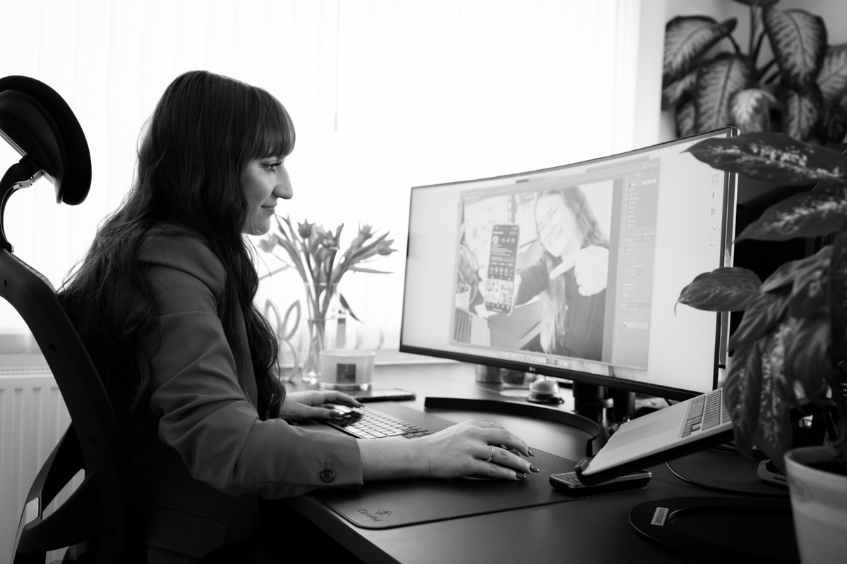 Mitarbeiterin der Webschmiede gestaltet Webdesign am Computer in einem modern eingerichteten Büro.