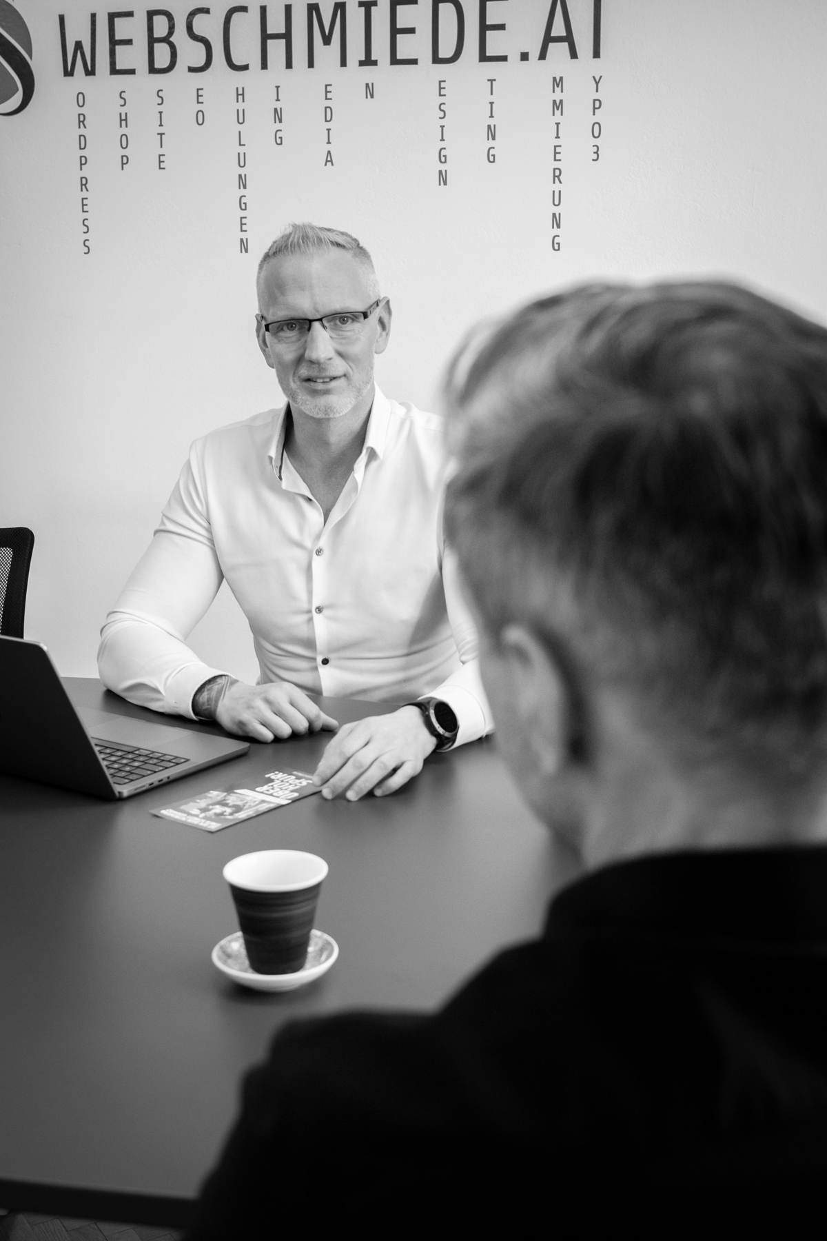 Mitarbeiter der Webschmiede-Agentur im Gespräch mit Kunde, Büro-Meeting über WordPress-Webdesign und SEO-Strategie.