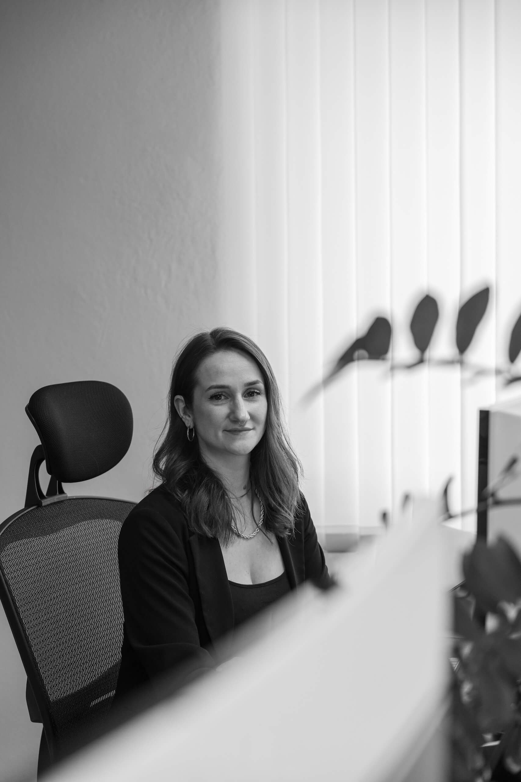 Mitarbeiterin der Webschmiede Oberwart sitzt am Schreibtisch in modernem Büro.