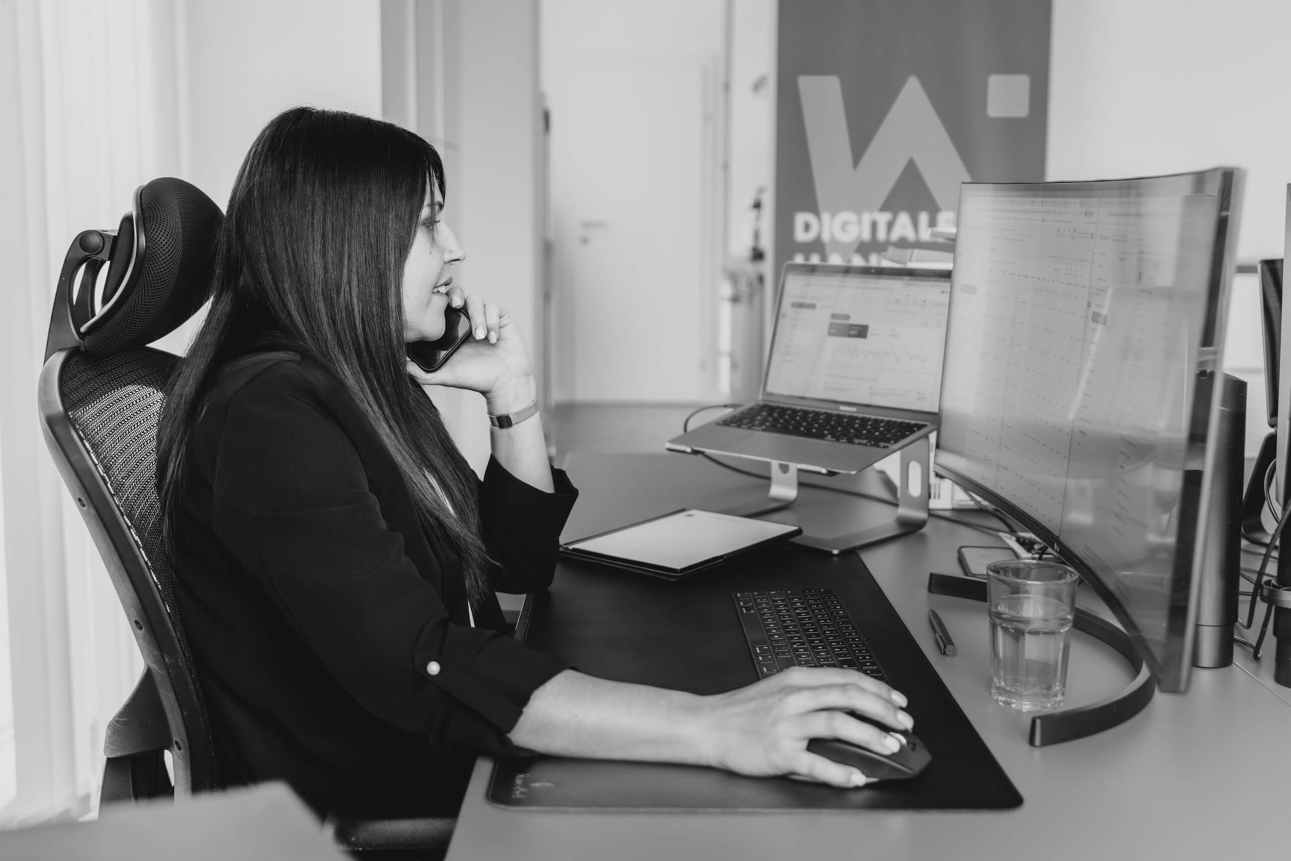Person telefoniert und arbeitet am Computer im Büro der Webschmiede, einer WordPress Agentur für Webshops und SEO in Oberwart.