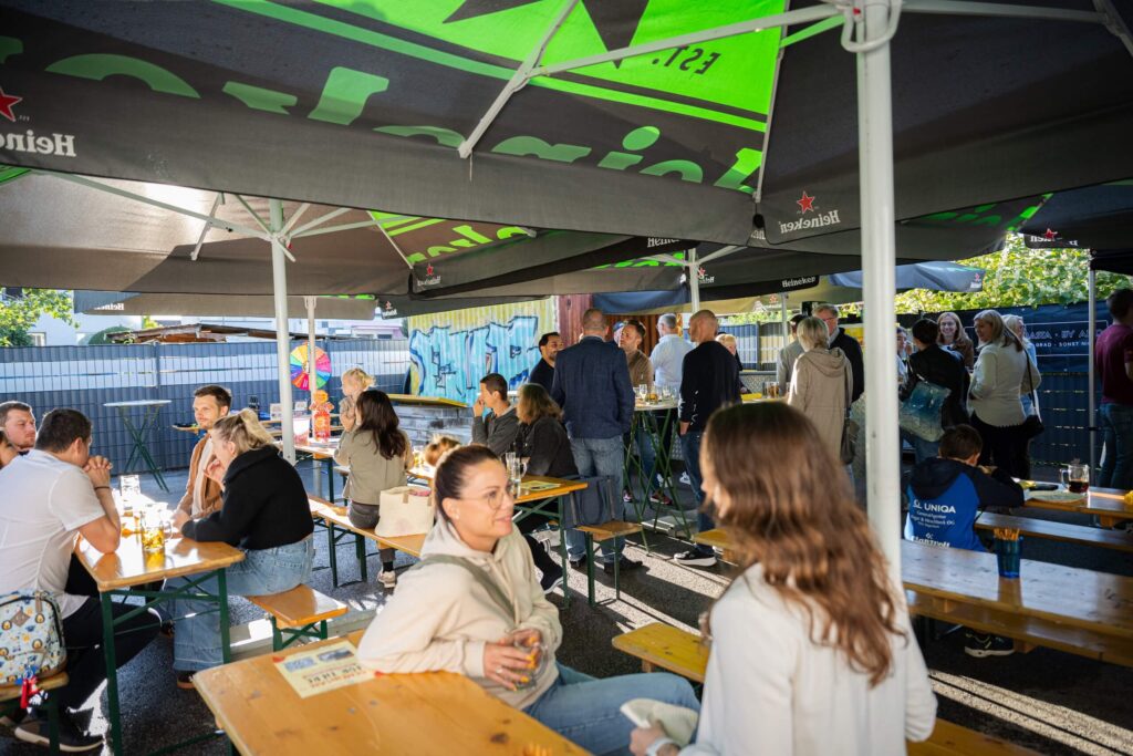 Menschen unterhalten sich in einem gemütlichen Außenbereich bei einem Event.