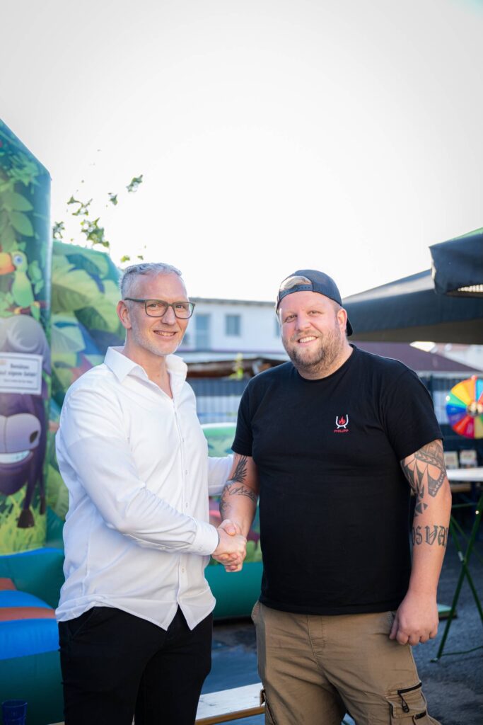 Zwei Männer schütteln sich die Hand bei einem Treffen der Webschmiede WordPress Agentur in Oberwart.